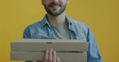 Karton kutuda pizza yakın çekim ve sarı arka planda erkek ellerinde kahve teslimatı için gitmek. Yemeği ve modern yaşam tarzını çıkar..