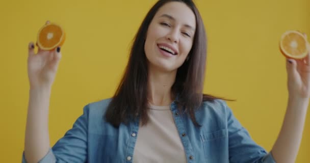 Portrét Šťastné Ženy Hrající Schovávanou Pomerančovými Úsměvy Žlutém Pozadí Koncept — Stock video