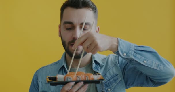 Slow Motion Portrait Joyful Young Man Eating Sushi Chopsticks Smiling — Stock Video