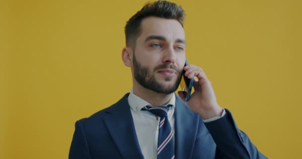 Sarı Arka Planda Cep Telefonuyla Konuşan Hırslı Adamının Portresi Modern — Stok video