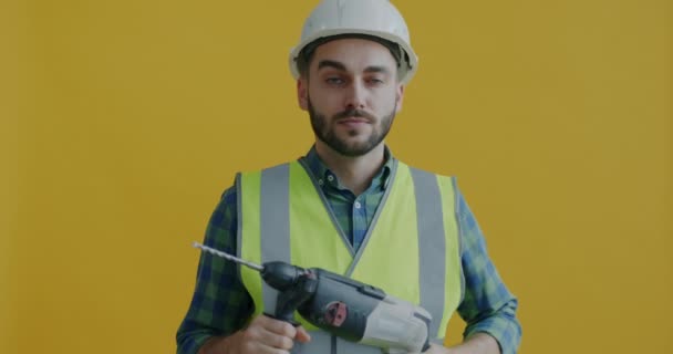 Güvenlik Üniformalı Elinde Elektrikli Matkapla Dolaşan Sarı Arka Planda Eğlenen — Stok video