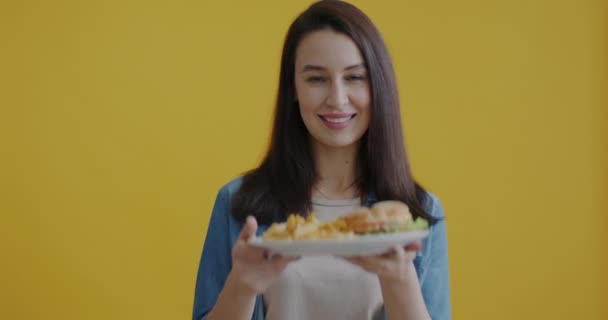 Портрет Счастливой Молодой Женщины Нюхающей Тарелку Вкусной Нездоровой Пищи Улыбающейся — стоковое видео