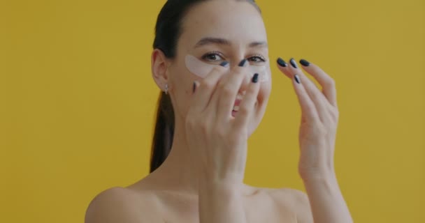 漂亮年轻女子的特写 用眼罩在黄色背景上微笑 皮肤护理和美容产品概念 — 图库视频影像