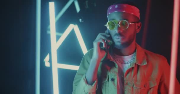 Cep Telefonuyla Konuşan Yakışıklı Afrikalı Amerikalı Adam Neon Işıklı Arka — Stok video