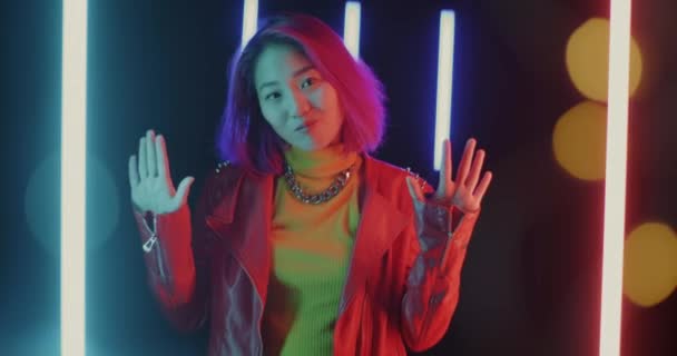 Neşeli Asyalı Kız Portresi Sallıyor Karanlık Uzayda Neon Işığıyla Gülümsüyor — Stok video