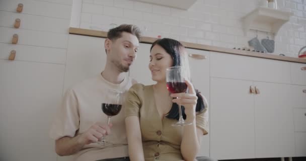 グラスを飲みながらワインを飲み 家でロマンチックな一日を楽しむ笑顔を愛するカップルのスローモーション 幸せな関係と飲料の概念 — ストック動画