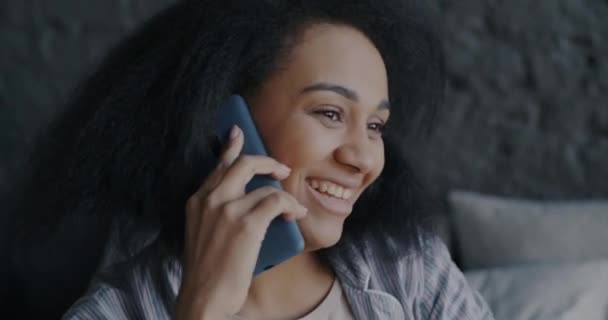 一个年轻女子在卧室里用手机聊天和微笑的画像 友好沟通和手机连接的概念 — 图库视频影像