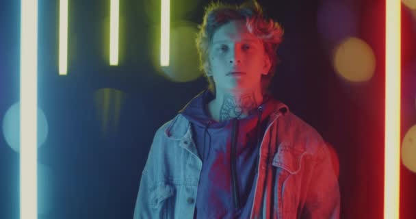 Portrét Klidného Mladého Muže Kouřícího Pásku Hledícího Kameru Stojící Neonovém — Stock video