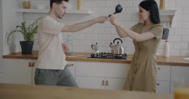 Verspieltes Junges Paar Beim Fechten Mit Geschirr Das Gemeinsam Hause — Stockvideo