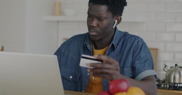 Afroamerykanin Dokonujący Płatności Online Kartą Kredytową Pomocą Laptopa Kuchni Domu — Wideo stockowe