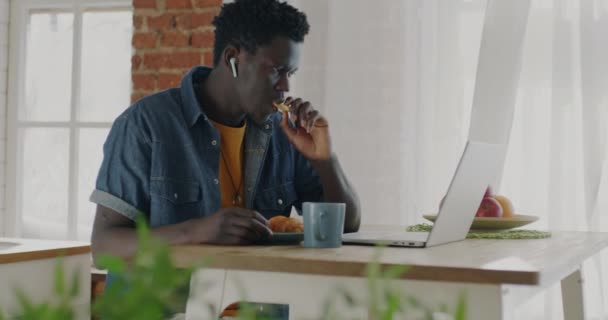 Glad Afroamerikansk Kille Äter Bakverk Dricka Och Titta Rolig Video — Stockvideo