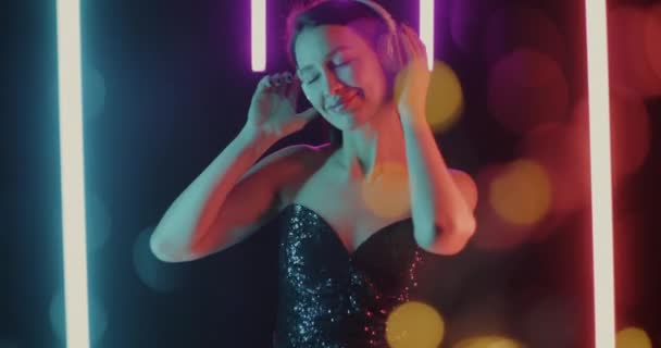 Zeitlupenporträt Einer Hübschen Dame Mit Kopfhörern Die Auf Neon Hintergrund — Stockvideo