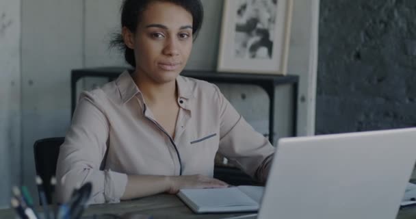 在办公室里的优雅的女商人的画像 她带着笔记本电脑坐在工作场所 看着相机 职业和现代技术概念 — 图库视频影像