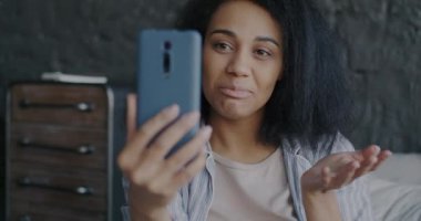 Neşeli genç bayan portresi çevrimiçi video konuşması yapıyor ve evde el sallıyor. İnsanlar ve iletişim konsepti.