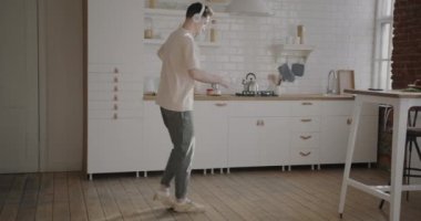 Tasasız adamın portresi evde bir fincan çayla dans ediyor ve kulaklıkla müzik dinliyor. İnsanlar ve iç konsept.