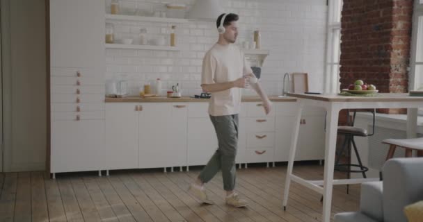 Zeitlupe Eines Jungen Mannes Mit Kopfhörern Der Der Küche Tanzt — Stockvideo