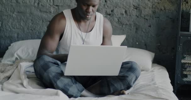 Porträtt Ung Afroamerikan Pyjamas Med Laptop Som Arbetar Sängen Hemma — Stockvideo