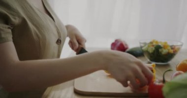 Mutfakta biberli sebze salatası yapan kızların el yapımı fotoğrafları. Diyet ve organik ürün kavramı.