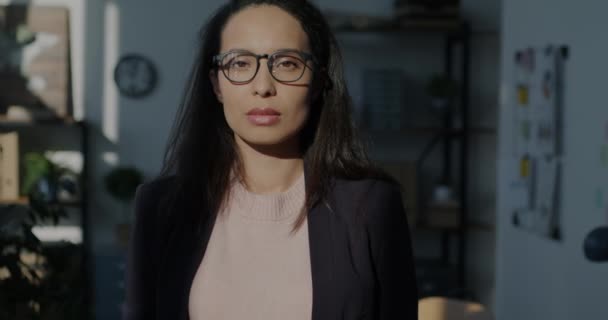 身穿西服的美丽的中东女人的慢镜头肖像和独立站在办公室里看着相机的眼镜 人与工作场所概念 — 图库视频影像