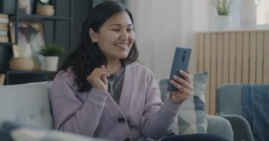 Tasasız bir öğrenci internet üzerinden konuşma yapıyor ve evde akıllı telefon kullanarak el sallıyor. Modern yaşam tarzı ve aygıtlar kavramı.
