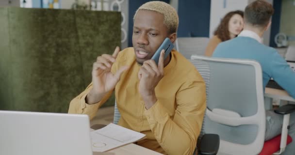 非裔美国商人正在用手机交谈 并在共用办公室里使用笔记本电脑 公司通信和工作场所概念 — 图库视频影像