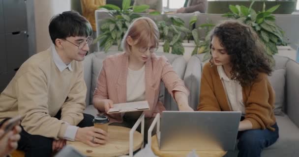 동료들은 창의적 사무실에서 일하는 노트북 화면을 가리키는 아이디어에 토론하고 있습니다 — 비디오