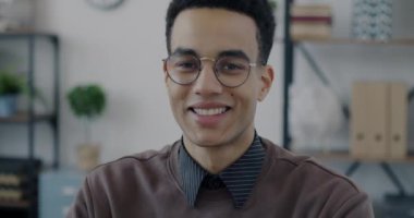 Gülümseyen ve ofisteki kameraya bakan Afro-Amerikan girişimci portresi. Pozitif duygu ve başarılı kariyer kavramı.