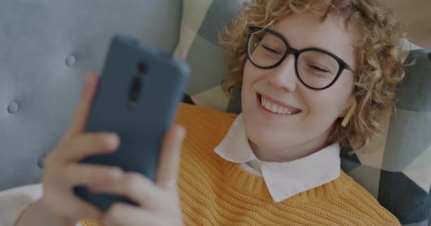 Akıllı Telefonuyla Mesajlaşan Kaygısız Genç Kadın Ekranlara Dokunuyor Evdeki Kanepede — Stok video