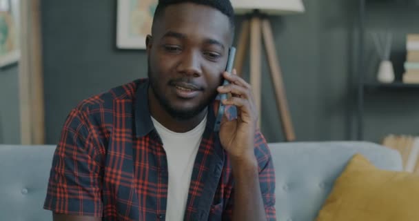 Neşeli Afro Amerikalı Adam Cep Telefonuyla Konuşuyor Gülümsüyor Evdeki Koltukta — Stok video