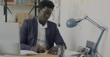 Yaratıcı Afrikalı Amerikalı girişimci sadece ofiste çalışan yapışkan notlar üzerine notlar yazıyor. İş etkinliği ve başarılı başlangıç konsepti.