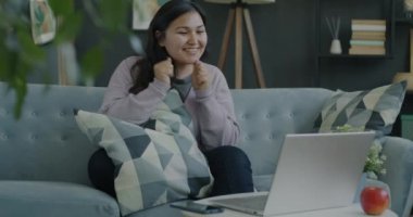 Bilgisayarla video görüşmesi yapan mutlu genç bir kadının portresi evde güzel haberler paylaşıyor. Sanal toplantı ve gayri resmi iletişim kavramı.