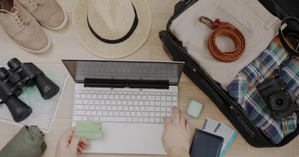 用笔记本电脑购买手提箱和在木制背景下看得见的旅行物品的度假旅行 用信用卡可以看到的头像 — 图库视频影像
