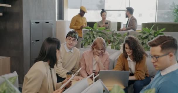 ビジネスチームの男性と女性は ラップトップを使用して話している現代のオープンスペースオフィスで協力しています コミュニケーションとコワーキングの概念 — ストック動画