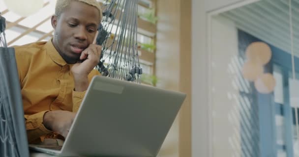 Funcionário Afro Americano Está Falando Celular Usando Laptop Sentado Espreguiçadeira — Vídeo de Stock