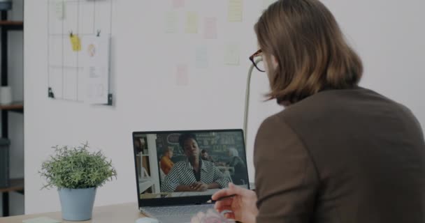 在办公室使用笔记本电脑进行在线视频通话时 商人与女同事交谈的背景图 通过现代技术讨论工作的人 — 图库视频影像