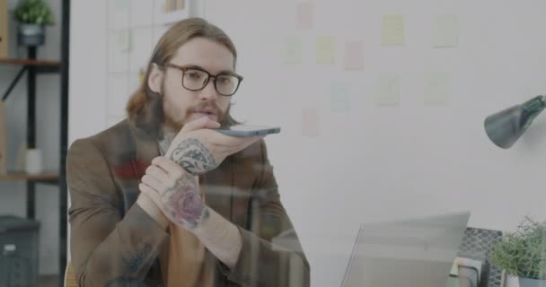 Молодой Человек Записывает Прослушивает Аудиосообщения Помощью Смартфона Офисе Татуированный Бизнесмен — стоковое видео