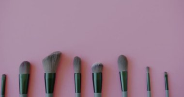 Pembe arka planda profesyonel makyaj fırça setinin üst görüntüsü. Modrn güzellik ürünü ve dekoratif kozmetik aksesuar.