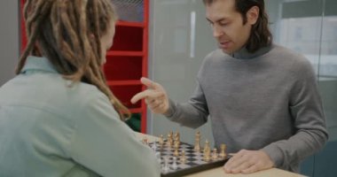 İş adamları teneffüste satranç oynar, güler ve dinlenir. Boş zaman aktivitesi ve ofis konseptinde takım çalışması..