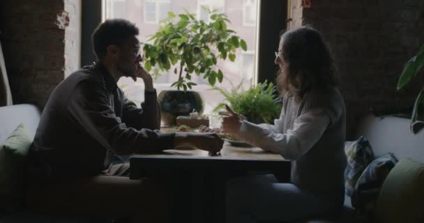 アフリカ系アメリカ人男性と白人女性の側面図カフェでの最初のデート中にコーヒーを話し 関係と公共の場の概念 — ストック動画