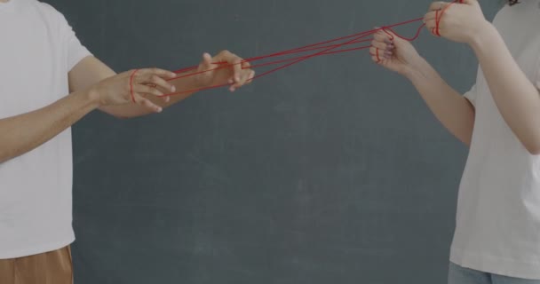 男人和女人用红色的绳子绑住双手 表达复杂的关系和非语言的交流 人与人的融合概念 — 图库视频影像