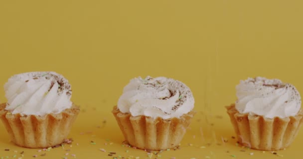 Close Delicious Cupcakes Colorful Sprinkles Falling Yellow Color Background Tasty — Stock Video