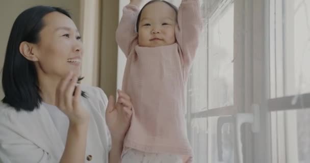 かわいい子供と遊んで陽気なアジアの女性の肖像自宅で屋内で拍手の手を話しています 肯定的な感情と幸せな家族の概念 — ストック動画