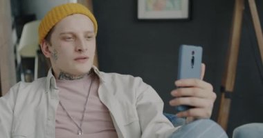 Evdeki iyi haberleri paylaşan yaratıcı adam çevrimiçi video görüşmesi yapıyor ve el kol hareketi yapıyor. Gençlik ve uzak iletişim kavramı.