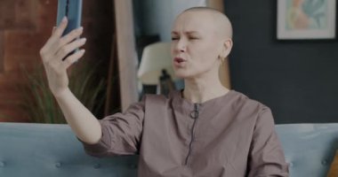 Tarz sahibi genç bir bayan evdeki video görüşmeleri sırasında gülüyor ve el sallıyor. İletişim ve milenyum kavramı.