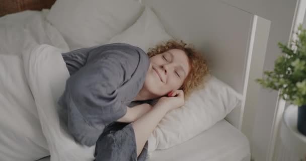 Porträtt Glad Ung Kvinna Pyjamas Som Vaknar Sängen Och Sträcker — Stockvideo