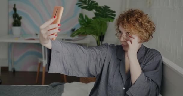 Pijamalı Akıllı Telefon Kamerasıyla Selfie Çeken Yatakta Eğlenen Çekici Genç — Stok video