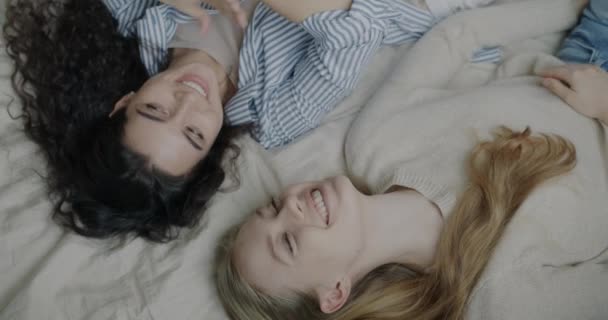 俯瞰美丽的年轻女子躺在床上聊天 面带微笑 一起享受着放松 友谊和闲暇时间概念 — 图库视频影像