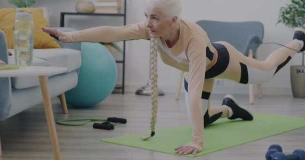Slow Motion Pensionerad Kvinna Sportkläder Gör Fysiska Övningar Ensam Inomhus — Stockvideo