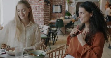 Mutlu genç bayan, kafe masasında oturan bayana hediye paketi veriyor. Özel etkinlik ve keyifli hediye konsepti.