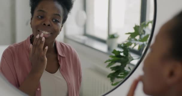 Портрет Привабливої Афроамериканської Жінки Яка Торкається Шкіри Губ Дивлячись Дзеркало — стокове відео